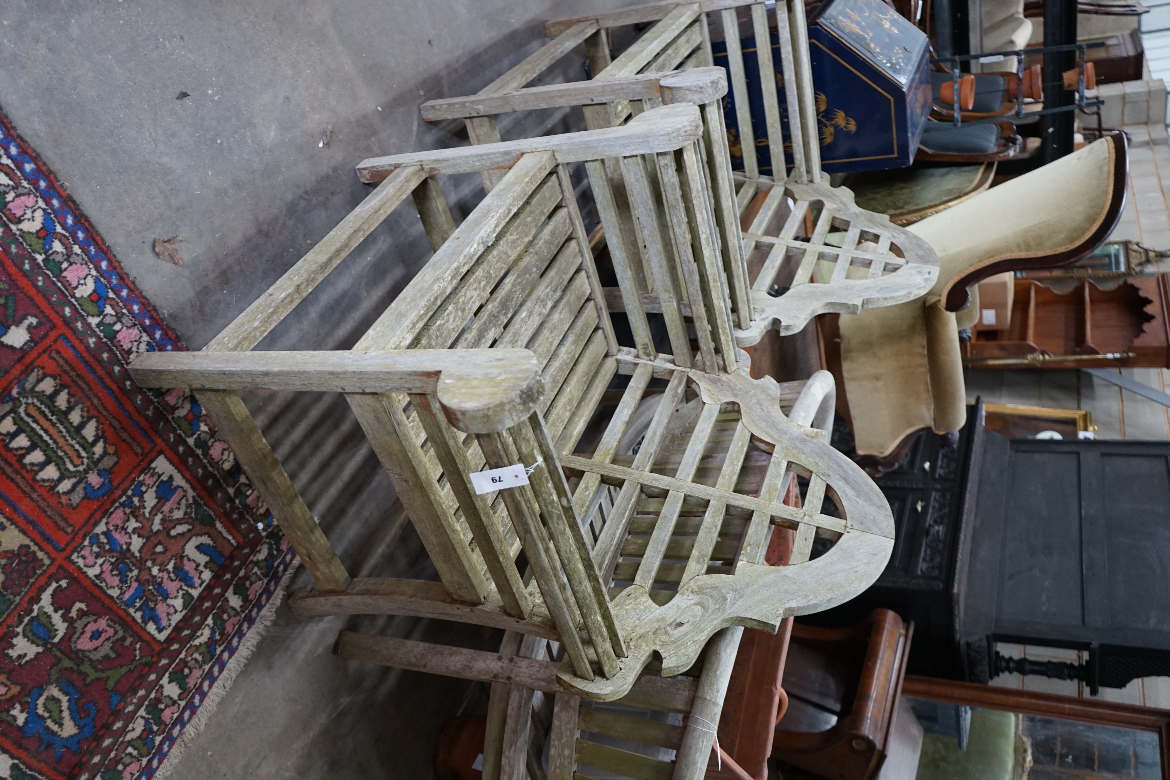 A pair of Lutyens style weathered teak garden armchairs, width 90cm depth 54cm height 105cm